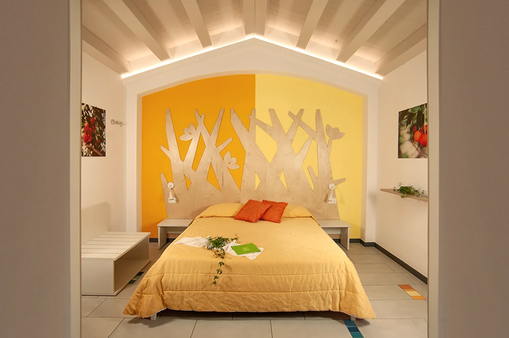 Ferme Bergi – Suite familiale Deluxe avec lits doubles, mobilier moderne aux tons bleus et jaunes, lumineuse et accueillante, à Castelbuono, Sicile.